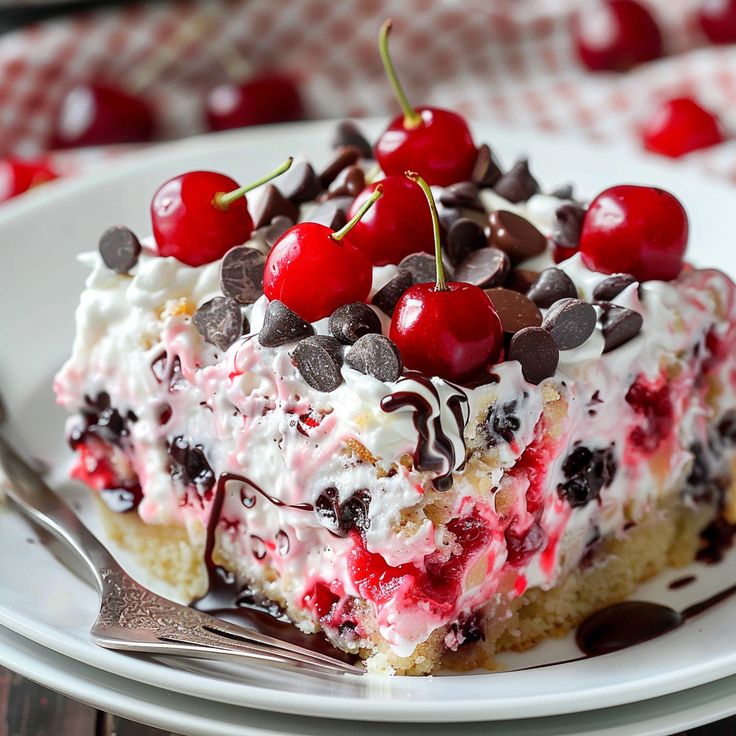 a piece of cake with cherries and chocolate chips on top is sitting on a plate