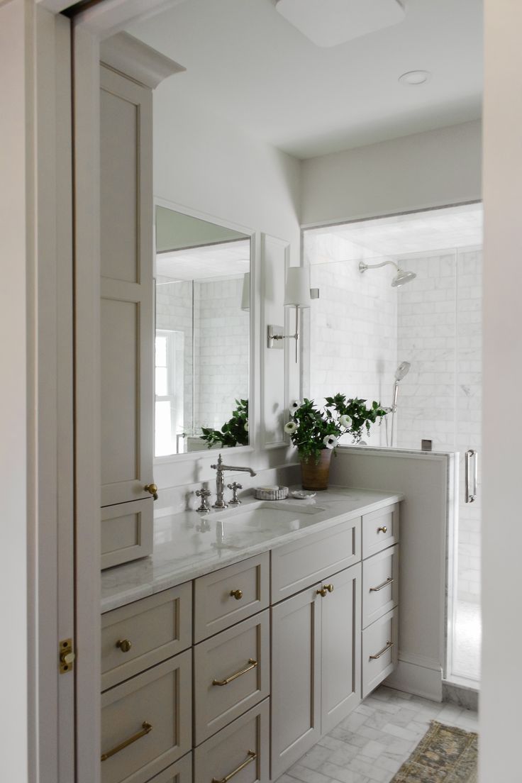 a white bathroom with two sinks and mirrors