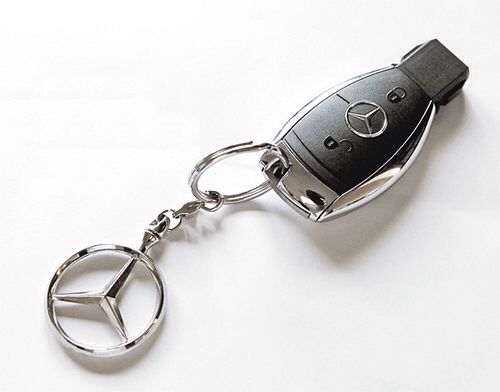 a mercedes keychain is shown with a mercedes logo on the front and side