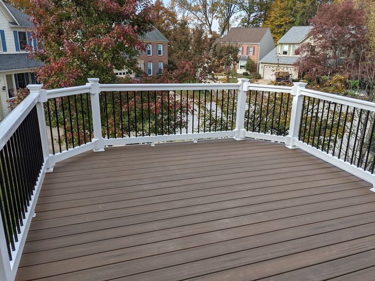 a wooden deck with white rails and railings