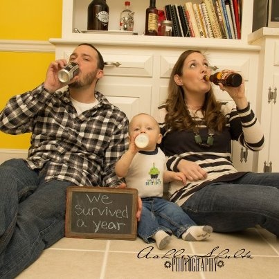 a man and woman are sitting on the floor drinking from their baby's bottles