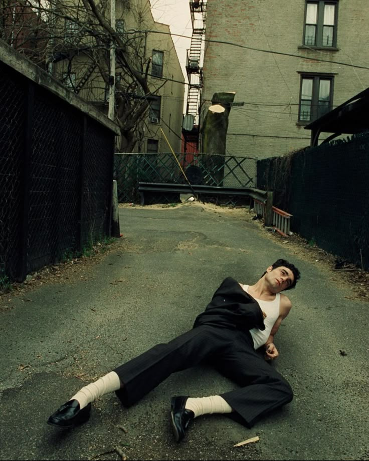 a man laying on the ground in an alley