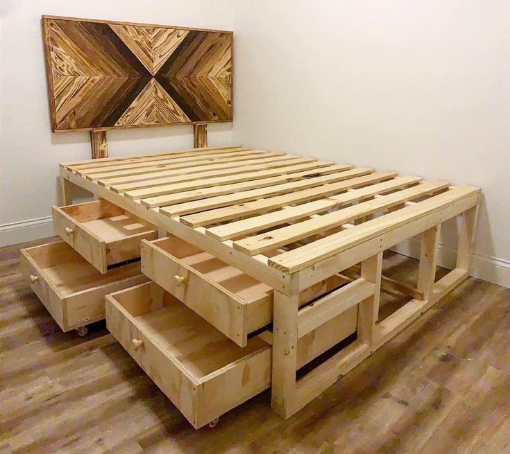 a wooden bed frame with drawers on the bottom and sides, in front of a white wall