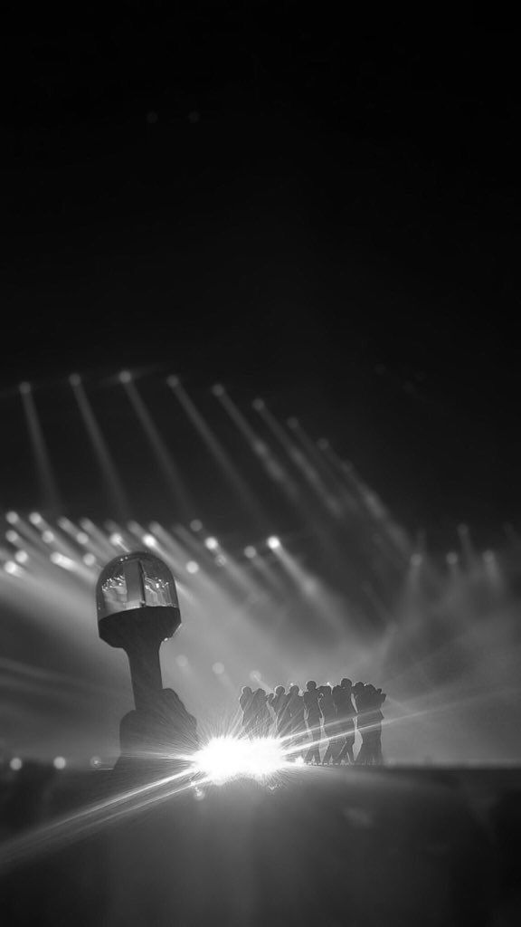 a black and white photo of some people in front of a stage with bright lights