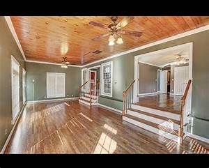 an empty living room with wood floors and ceiling fan