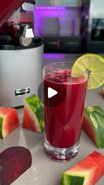 a glass filled with liquid next to slices of watermelon