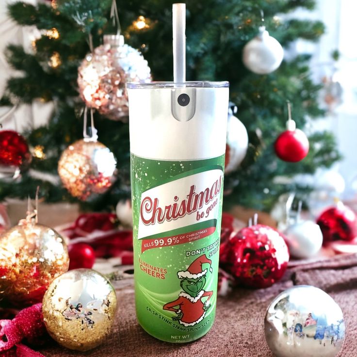 a bottle of christmas deodorant sitting next to some ornaments and a tree