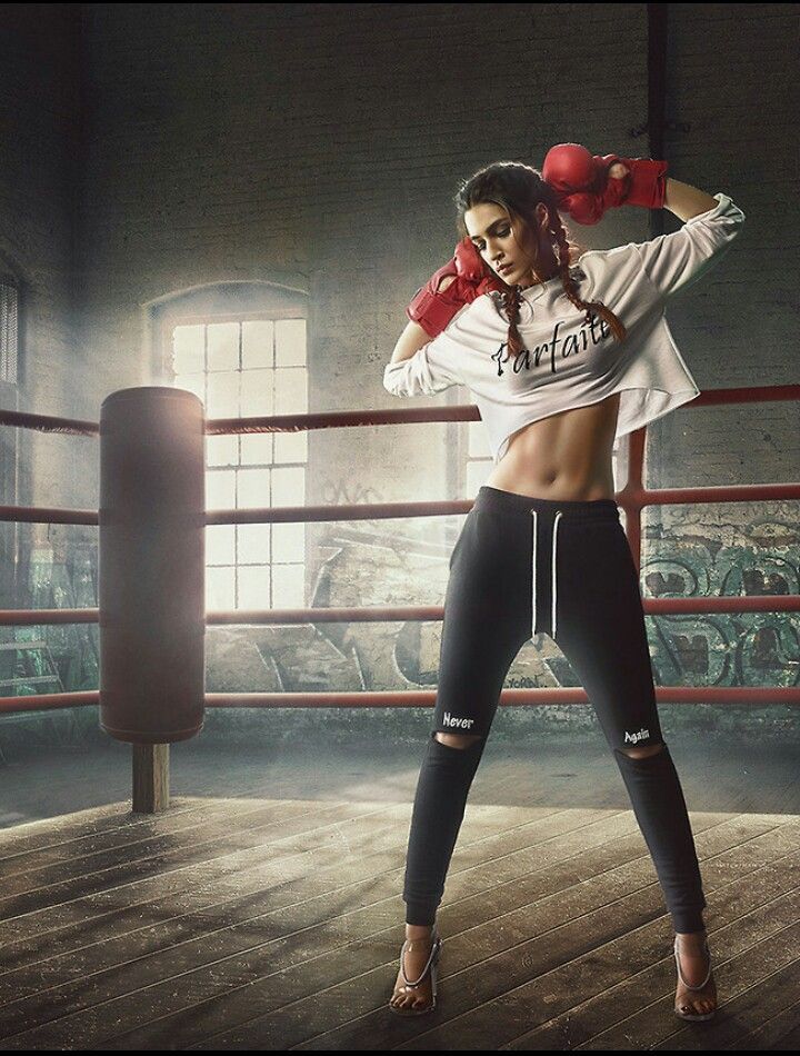 a woman in black and white boxing gear posing for the camera with her hands on her hips