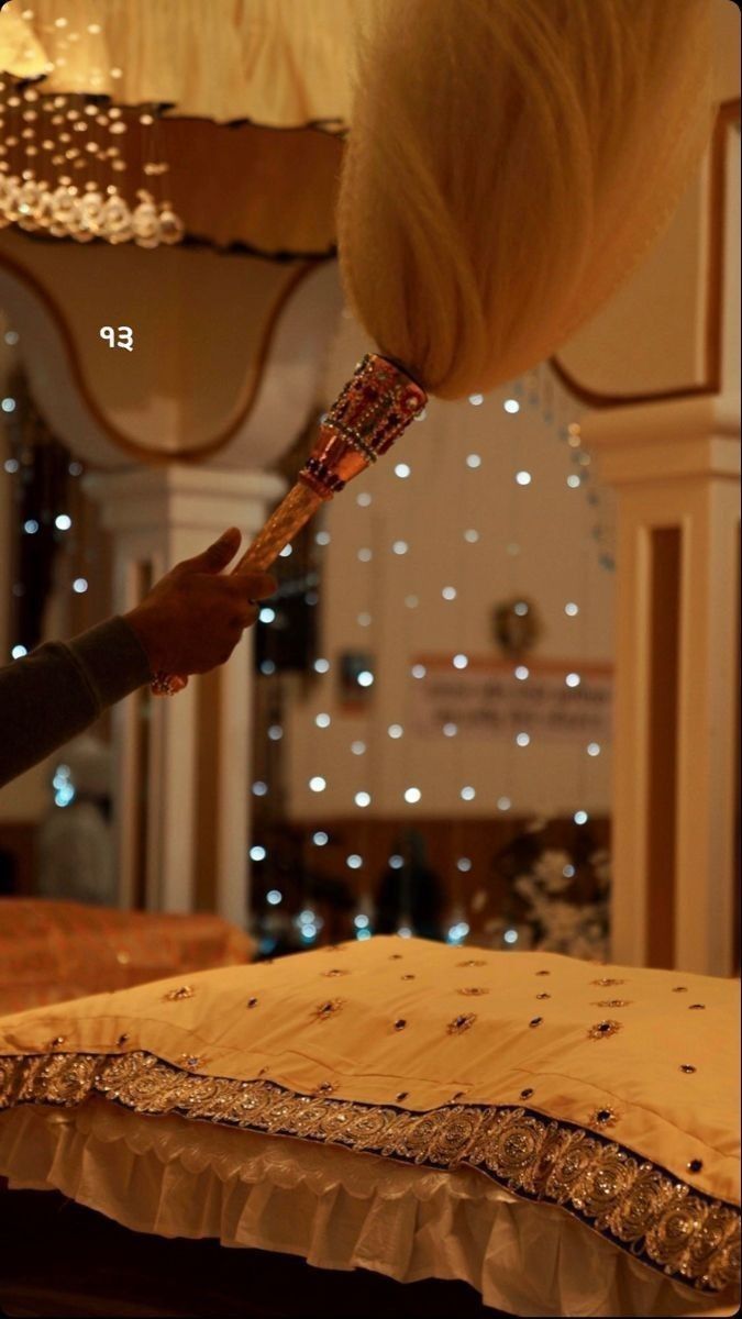 a woman is blow drying her hair on the bed with lights in the room behind her