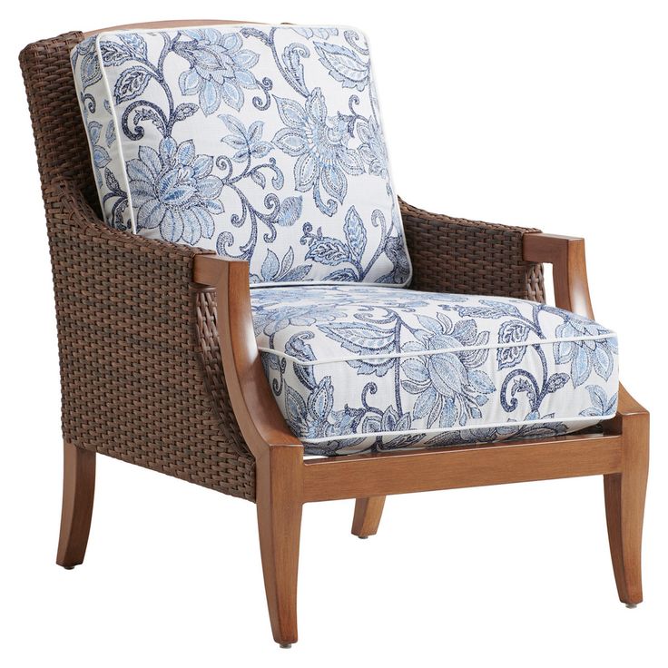 a wicker chair with blue and white floral print upholstered on the back