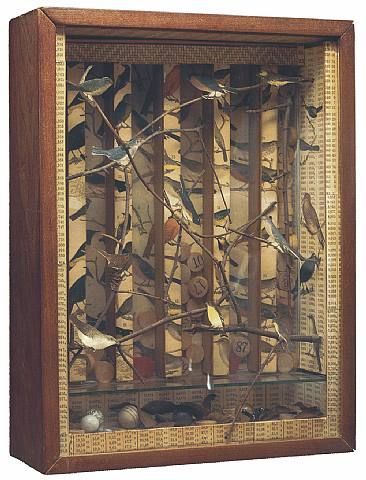 a wooden display case with birds on it's sides and branches in the middle