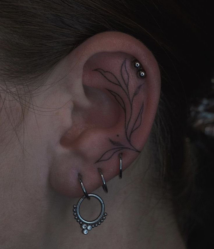 a woman's ear is adorned with piercings