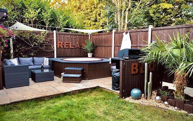 a backyard with a hot tub and patio furniture