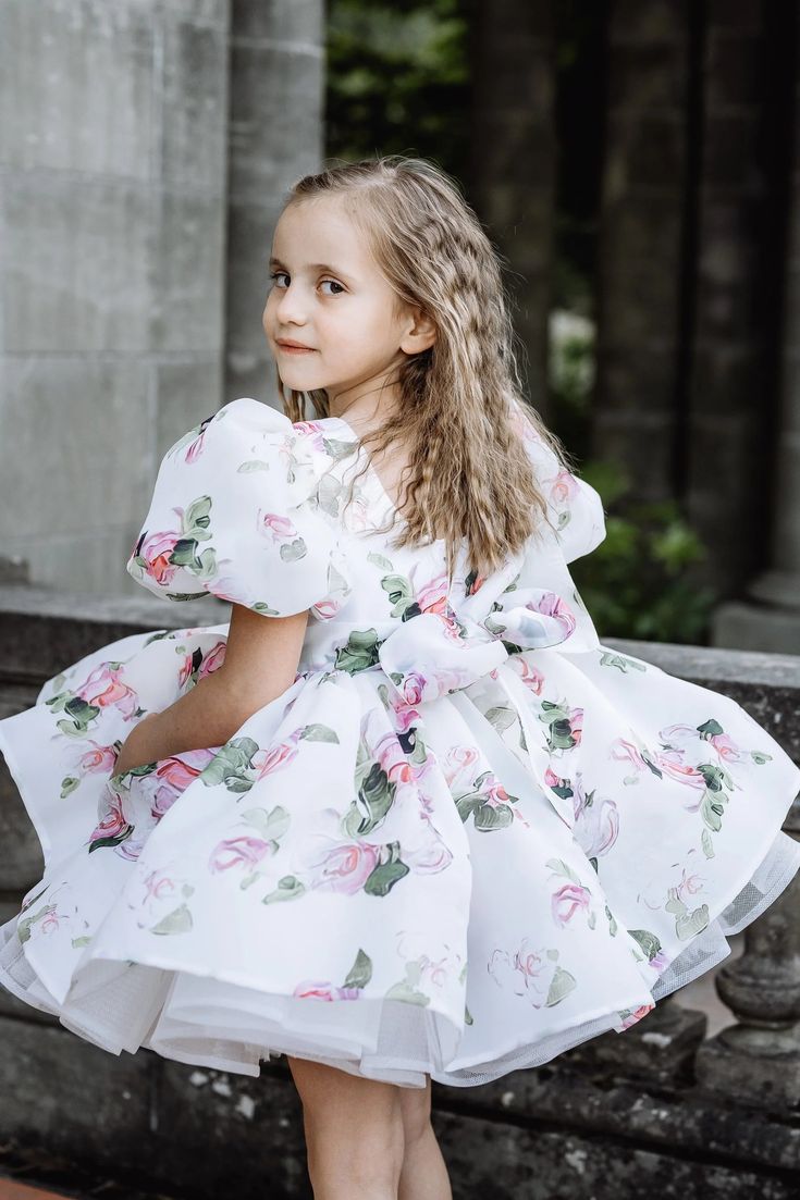 The adorable handmade Organza Print Foral Dress is full of tulle layers and lined in soft organic cotton for comfort. Your little princess will be the belle of the ball in this stunning twirl-ready floral gown featuring puff sleeves and a full skirt with ruffle mesh detail. Made in Europe. Bridal Collection. Spring Tulle Gown With Ruffles, Spring Ruffled Ball Gown Dresses, Spring Princess Dress With Fitted Bodice And Tulle, Fitted Princess Dress With Ruffles For Garden Party, Spring Ball Gown Dresses With Ruffles, Spring Ball Gown Dress With Voluminous Skirt, Whimsical Fitted Tulle Dress, Spring Princess Dress With Ruffled Skirt, Whimsical Ruffled Tutu Dress For Garden Parties