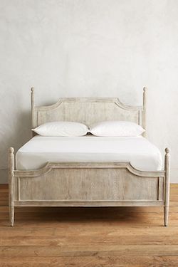 a white bed sitting on top of a wooden floor