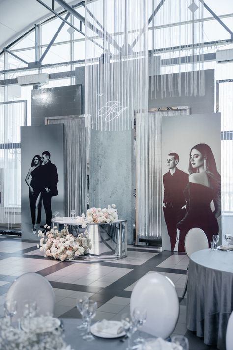 a room filled with tables and chairs covered in white flowers on top of it's black and white checkered floor