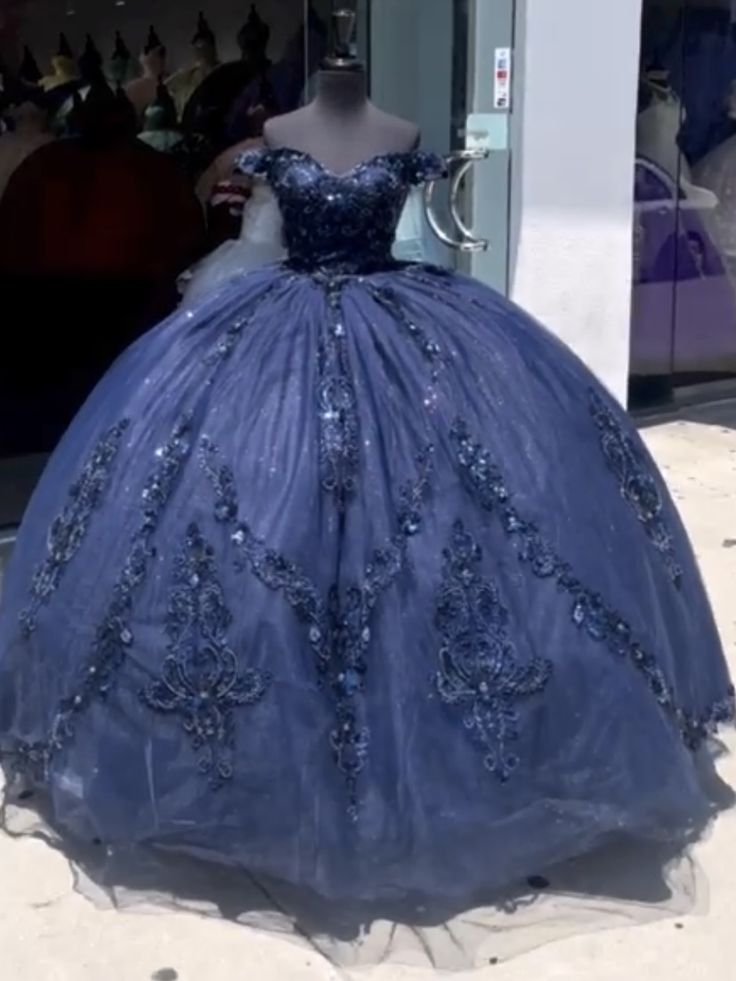 a blue ball gown on display in front of a store