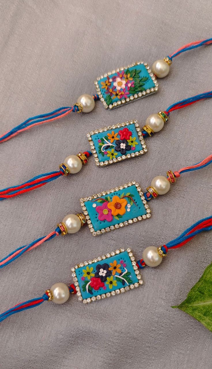 three colorful beaded bracelets with flowers and pearls on the end of each strand