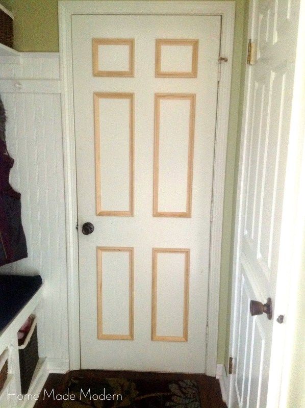 a white door in a green room next to a black and white checkered rug