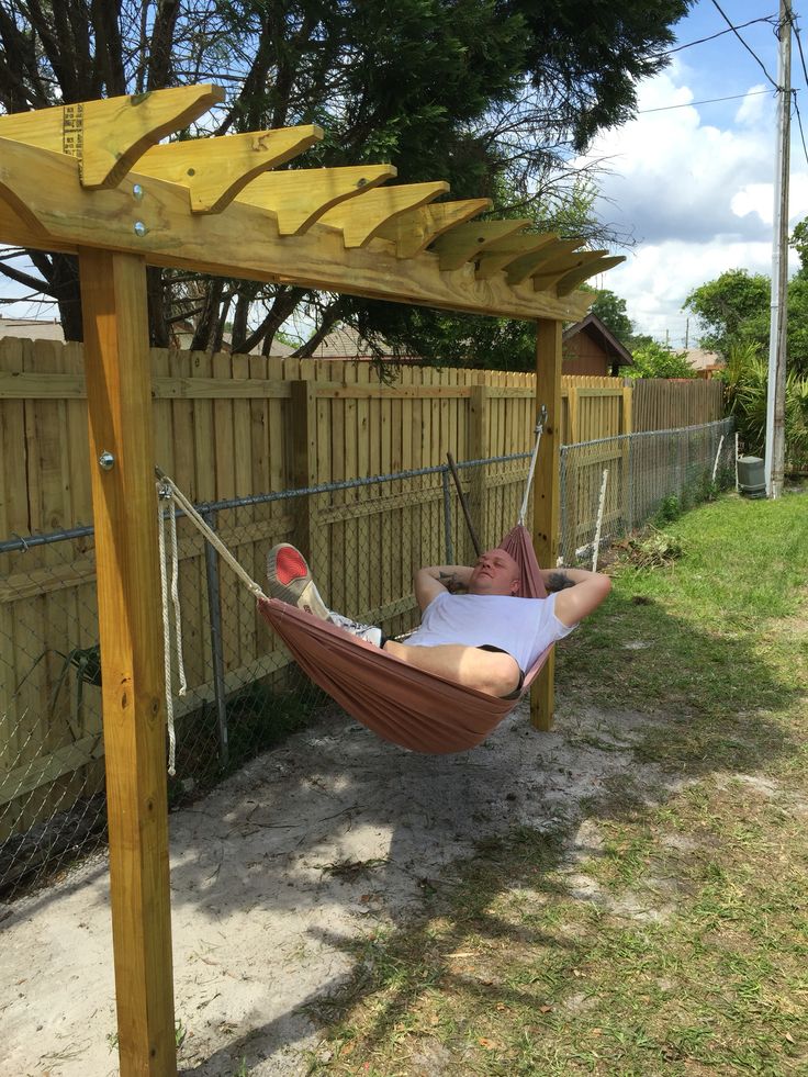 a man laying in a hammock with his feet on the ground