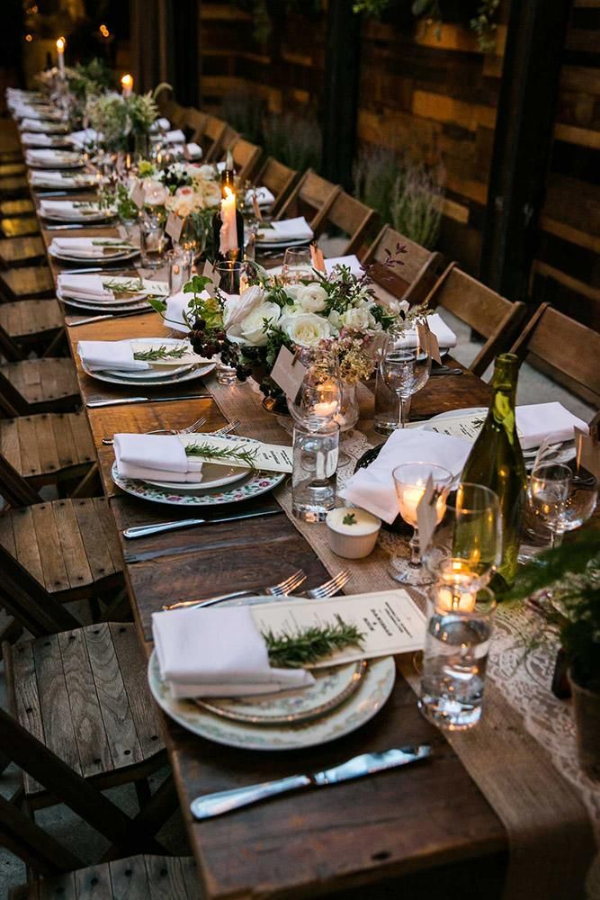 a long table is set with place settings and candles