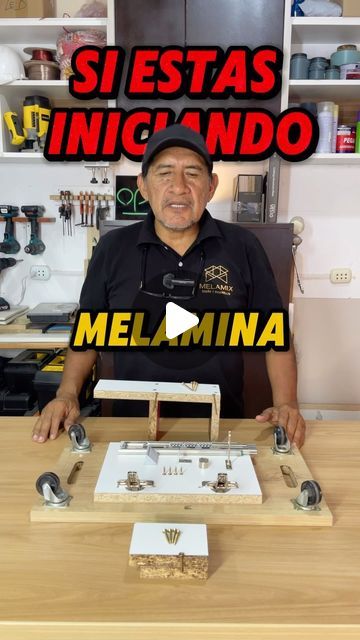 a man sitting in front of a wooden table with metal parts on top of it