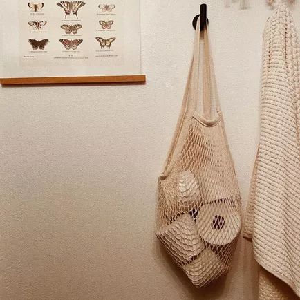 a wall hanging on the side of a bathroom next to a towel rack and other items