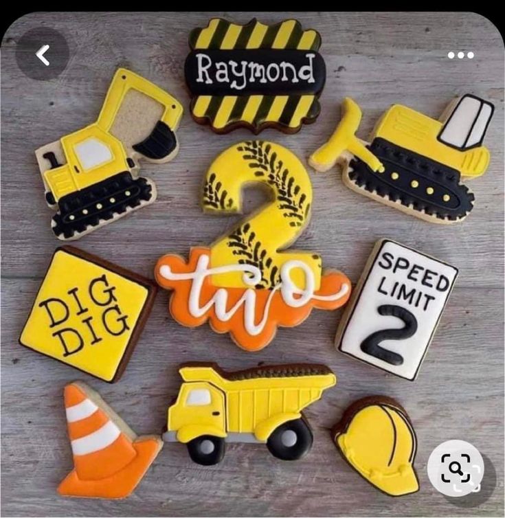 decorated cookies with construction theme are arranged on a table