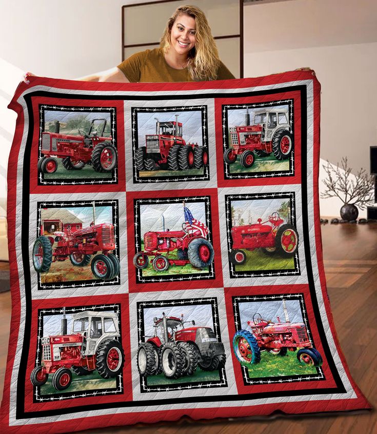 a woman holding up a quilt made to look like an old red farmall tractor