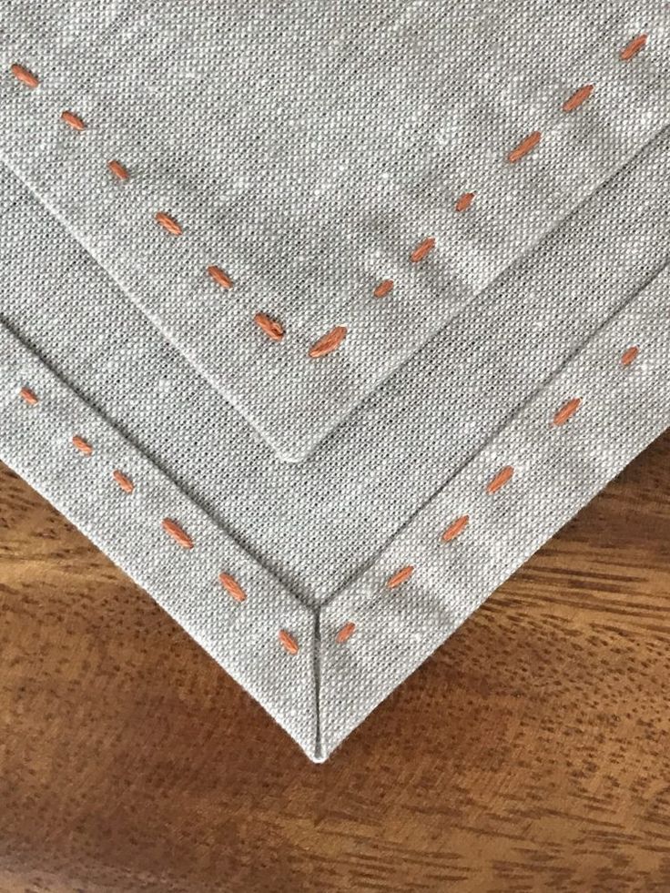 a close up of a piece of cloth on a wooden surface with holes in it