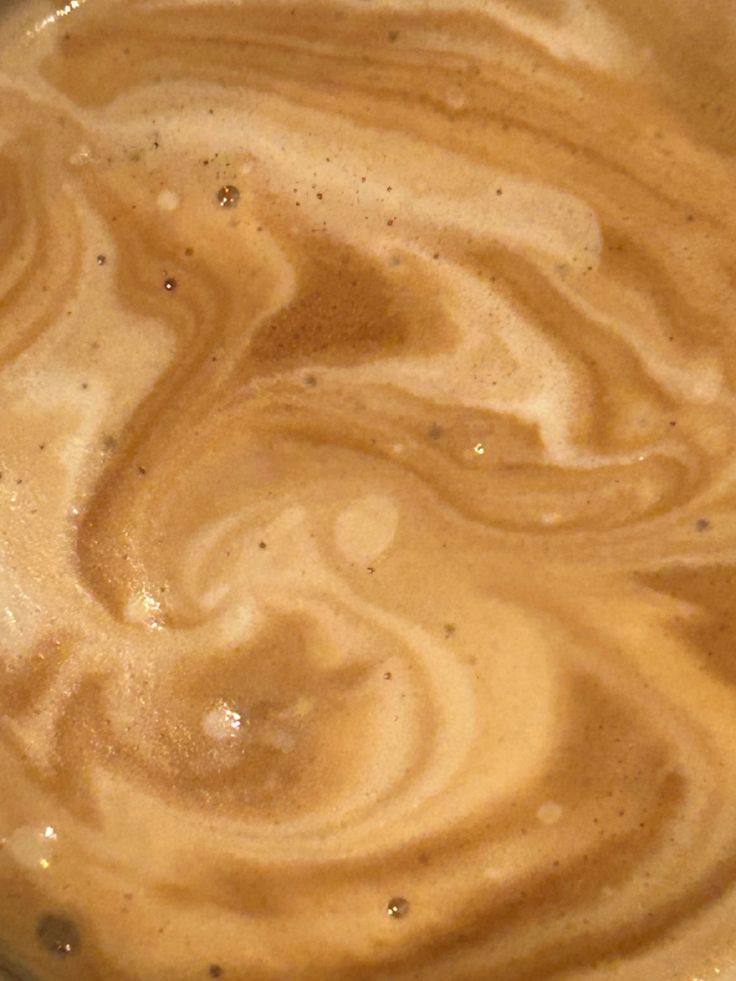 there is a cup of coffee with swirls in it