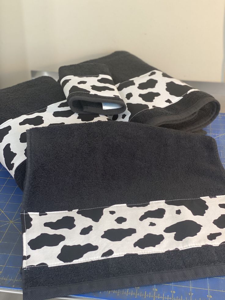 two black and white towels sitting on top of a cutting board