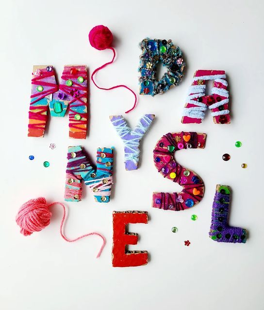 the letters are made up of yarn and plastic beads, which spell out their name