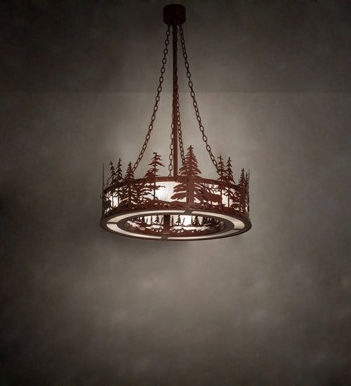 a chandelier hanging from the ceiling in a dark room with trees on it