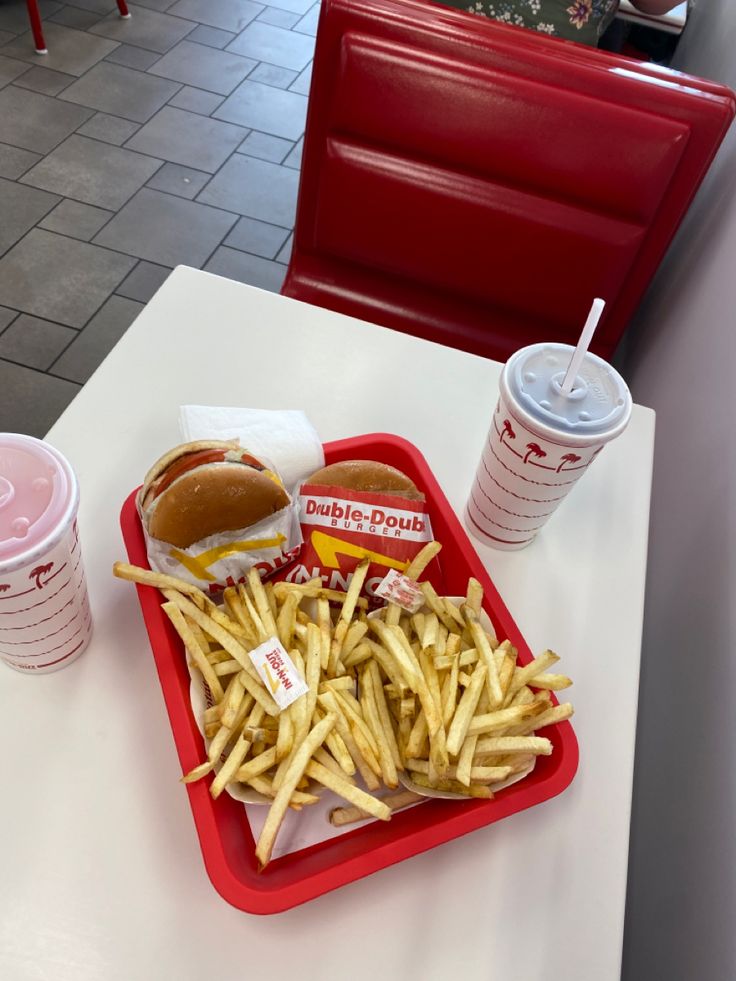 a tray filled with french fries and a hot dog on top of a white table