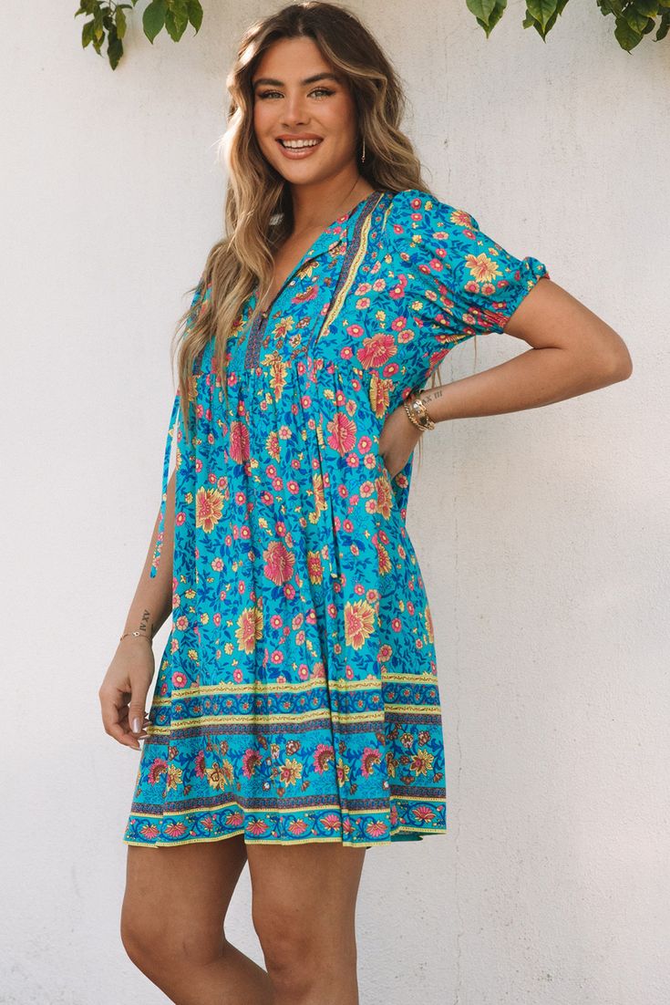 Blue Floral Print Empire Waist Flowy Dress Blue Flowy Boho Dress With Short Sleeves, Blue Bohemian Knee-length Dress, Blue Short Sleeve Boho Sundress, Blue Bohemian Mini Dress Knee-length, Flowy Blue Boho Dress With Floral Print, Blue Bohemian Knee-length Mini Dress, Blue Knee-length Mini Dress For Vacation, Casual Turquoise Floral Print Dress, Blue Floral Print Boho Sundress