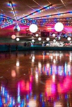 an empty dance floor with lights hanging from the ceiling and disco balls on the ceiling