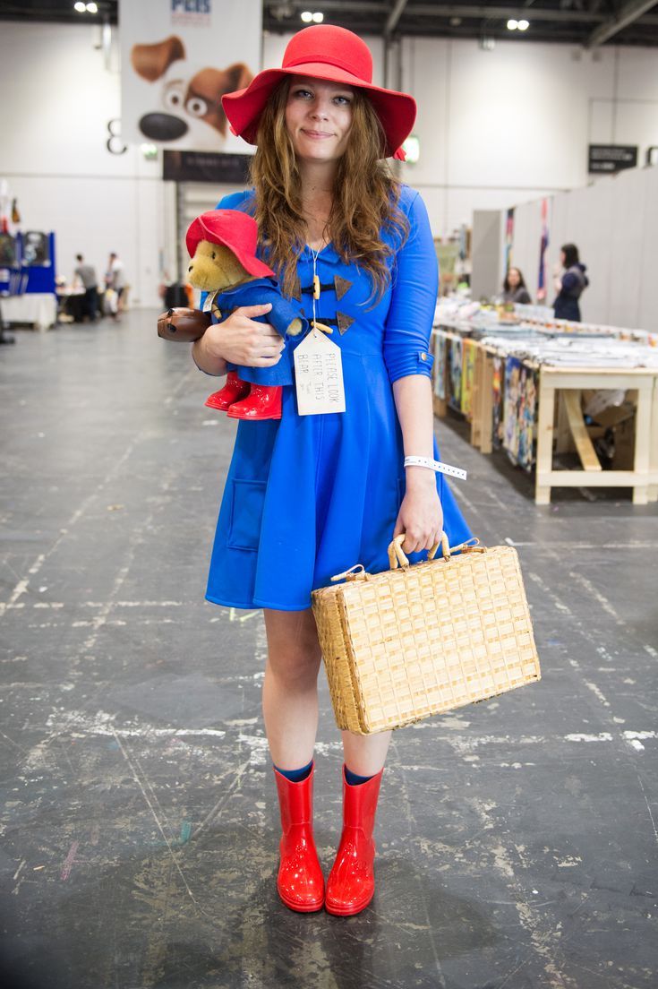 a woman in blue dress and red hat holding a basket