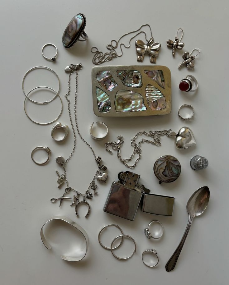 a table topped with lots of different types of jewelry and rings on top of it