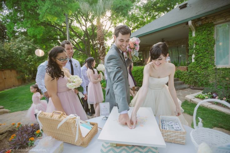 a bride and groom are cutting their wedding cake at the end of an outdoor ceremony