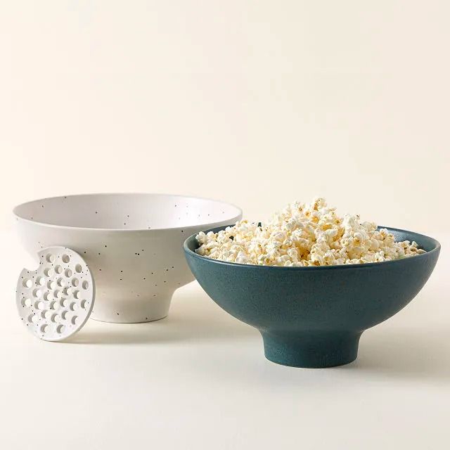 two bowls filled with popcorn sitting next to each other