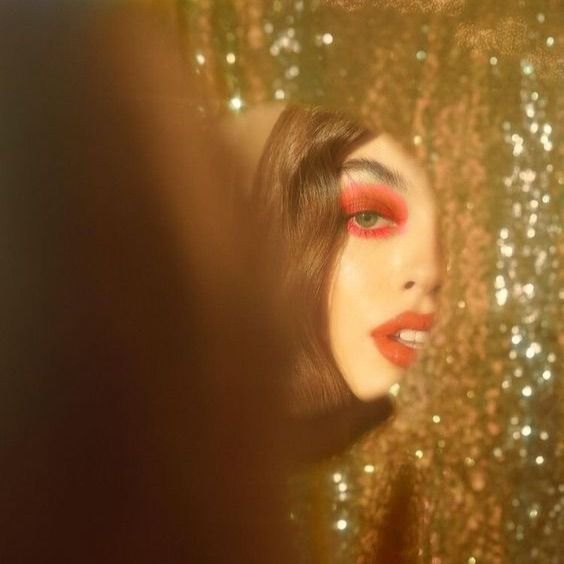 a woman's face is seen through the glittered curtain in front of her