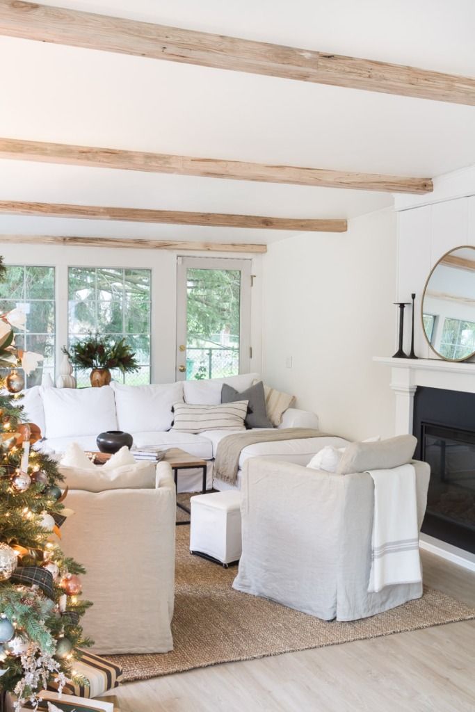 a living room filled with furniture and a christmas tree in front of a fire place