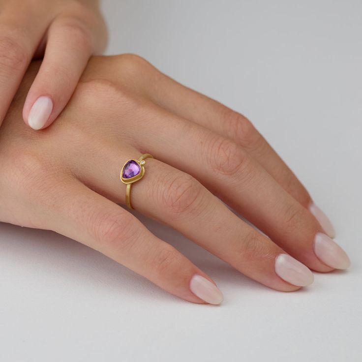 This gorgeous ring features a lavender-pink, rose cut sapphire wrapped in warm 22k gold, and accented with a single sparkling diamond. This ring is lovely on its own, and stacks beautifully with others in the collection. The setting measures approximately 6.5mm x 7.5mm. 18k gold 1.5mm, hammered band. Matte finish. Yellow Gold Pink Sapphire Gemstone Ring, Gold Jewelry With Rose Cut Diamonds And Pink Sapphire, Anniversary Pink Sapphire Ring With Rose Cut Diamonds, Yellow Gold Heart Cut Ring With Rose Cut Diamonds, Anniversary Jewelry With Rose Cut Diamonds And Pink Sapphire, Purple Rose Cut Diamond Ring As A Gift, Yellow Gold Pink Sapphire Birthstone Ring, Gold Pink Sapphire Birthstone Ring Gift, Yellow Gold Diamond Ring With Rose Cut Pink Sapphire