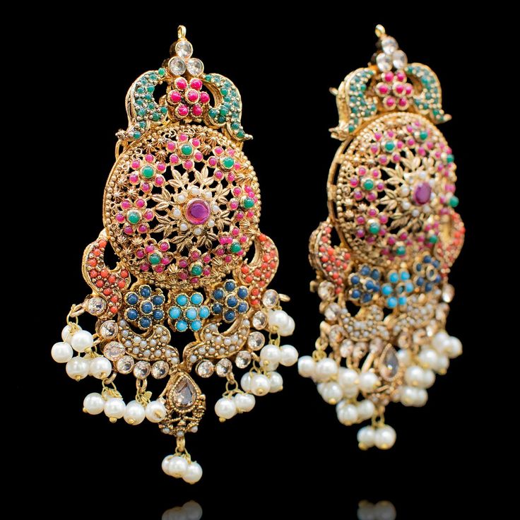 Incorporate the timelessness of heritage pieces with glistening of nauratan that makes heirlooms for generations! Dainty and elegant, this royal looking nauratan set with multiple strands of pearl moti, exquisitely enhancing the beauty of your festive attire will transcends the rest of the time. The set includes a long mala, a pair of stunning earrings and a maang teekah. Approximate mala length is 15" and approximate earrings length is 4". Gold-plated on high-quality brass as base metal. Made b Elegant Traditional Wear With Stone Work For Festivals, Elegant Ceremonial Traditional Wear With Stone Work, Elegant Festive Jhumkas With Zari Work, Elegant Festive Zari Work Jhumkas, Festive Elegant Jhumkas With Zari Work, Elegant Multicolor Chandbalis For Festive Occasions, Elegant Sets With Peacock Design For Diwali, Elegant Multicolor Festive Chandbalis, Eid Festive Traditional Wear With Stone Work