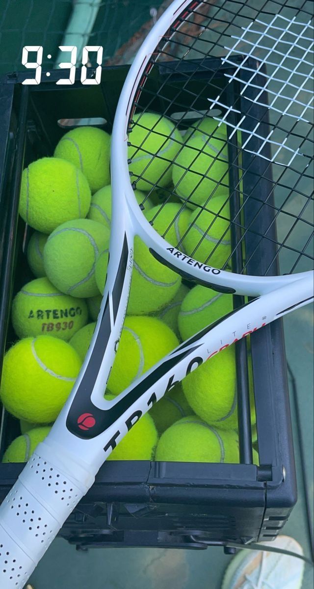 a racket and tennis balls in a box