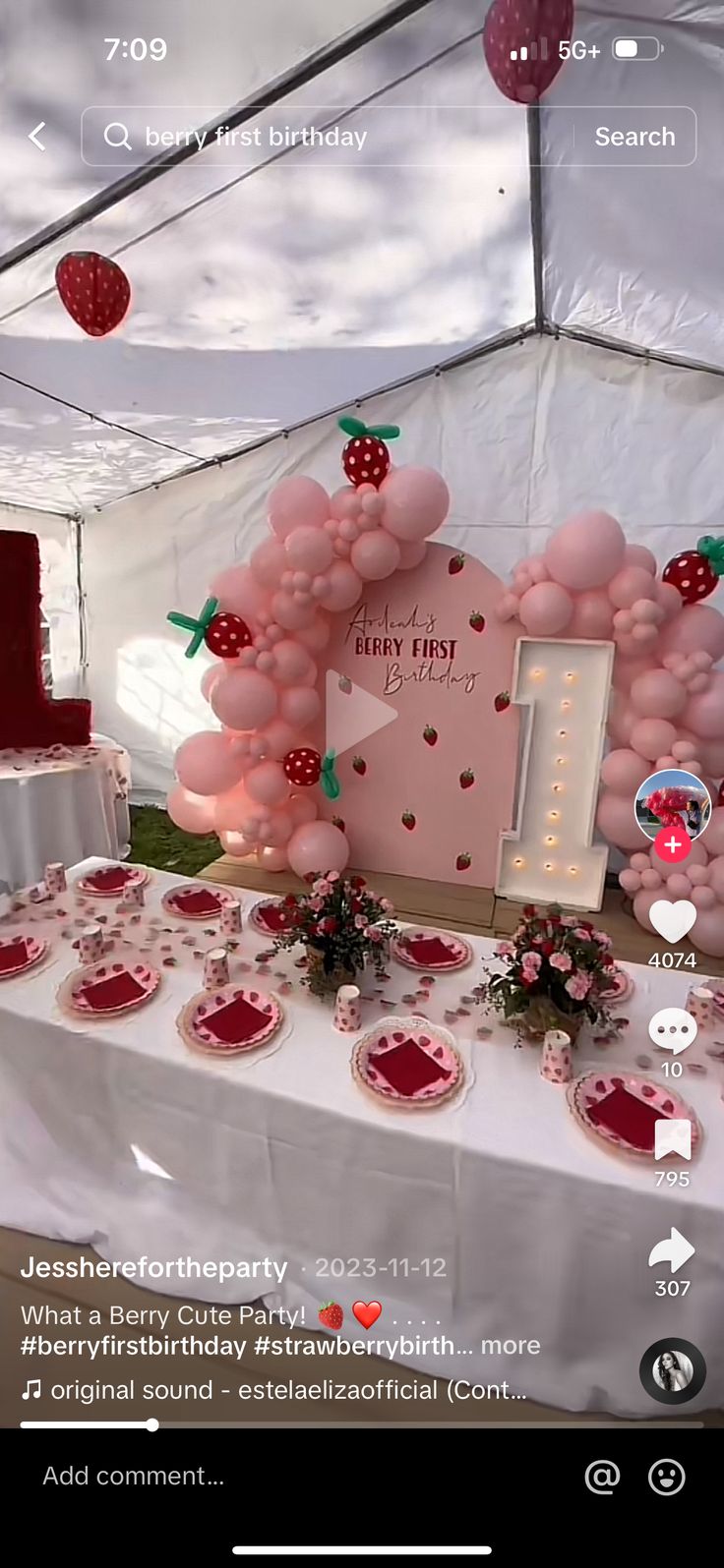 the table is set up with pink balloons and strawberrys on it, along with other decorations