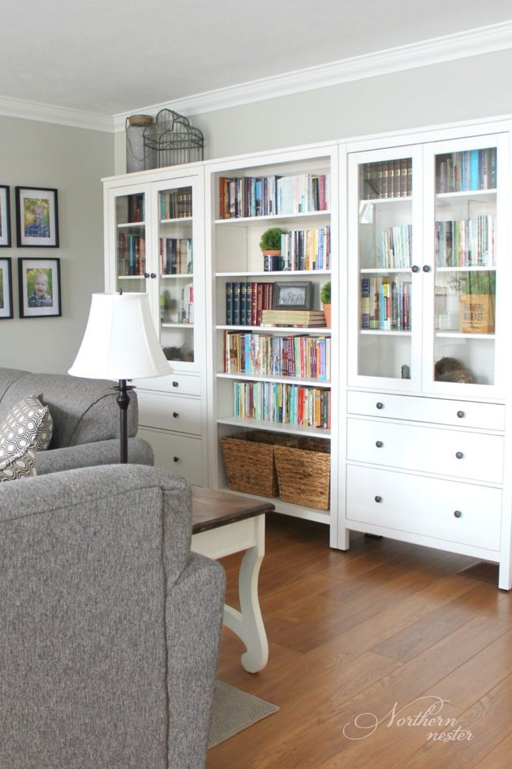 a living room filled with furniture and lots of books on the bookcases in front of it