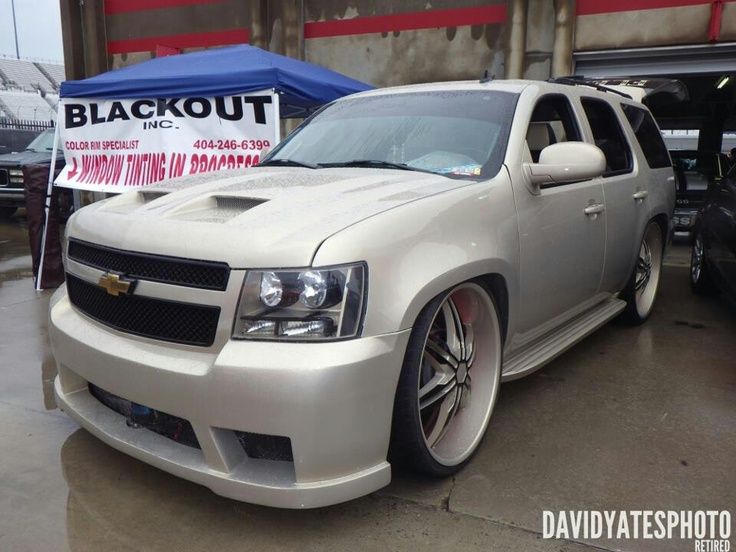 a white car parked in front of a blackout sign and some other cars behind it