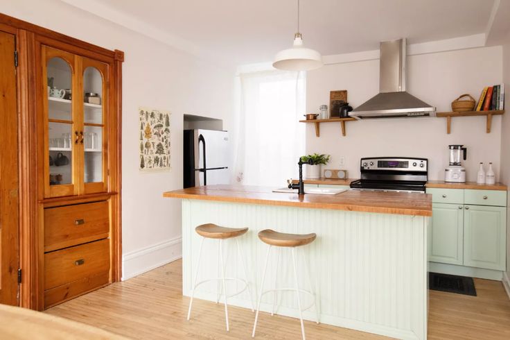 a kitchen with wooden floors and white walls